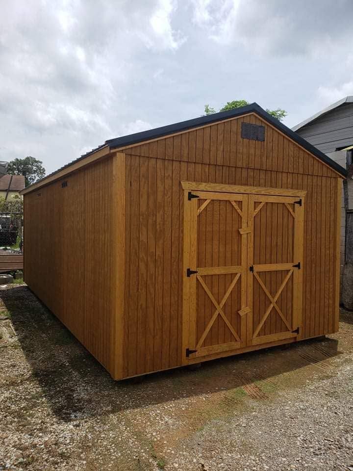 Wooden garden shed with double barn-style doors and a small gable roof under a cloudy sky