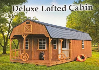 Rustic brown lofted cabin with black roof, porch, wagon wheels, and text reading “Deluxe Lofted Cabin”