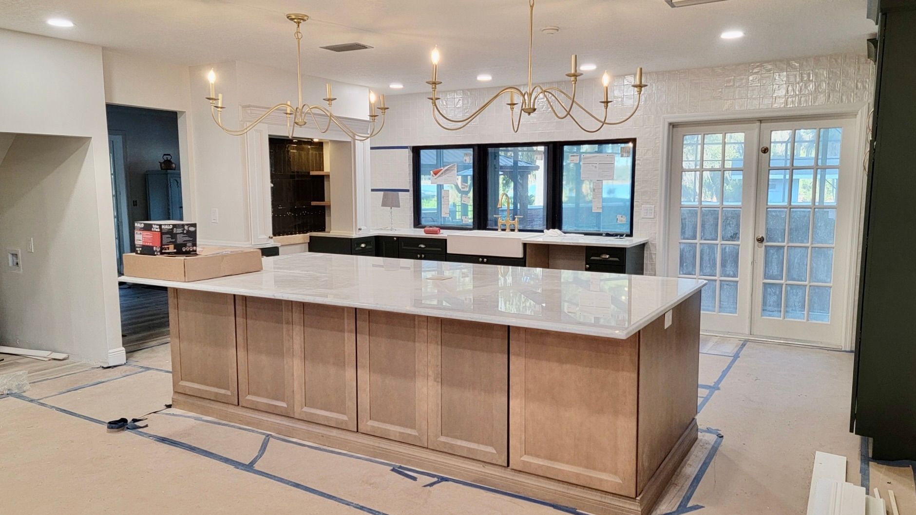 A kitchen under construction with a large island in the middle.