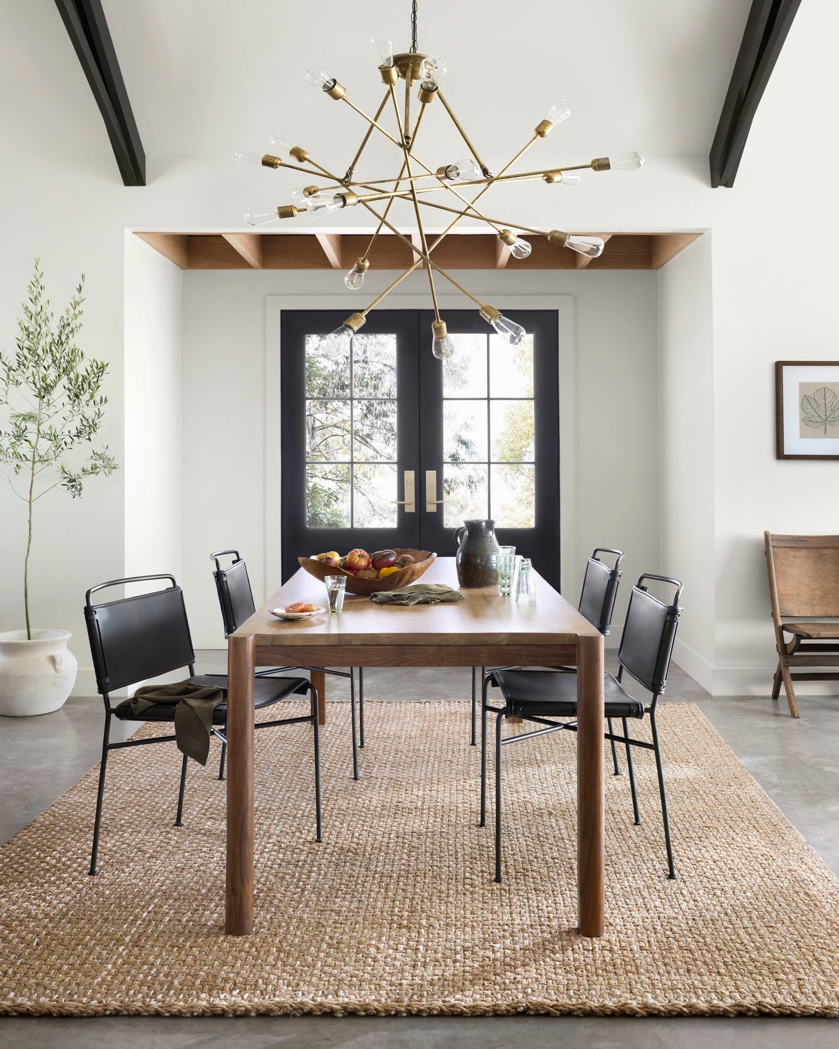 A dining room with a table and chairs and a rug
