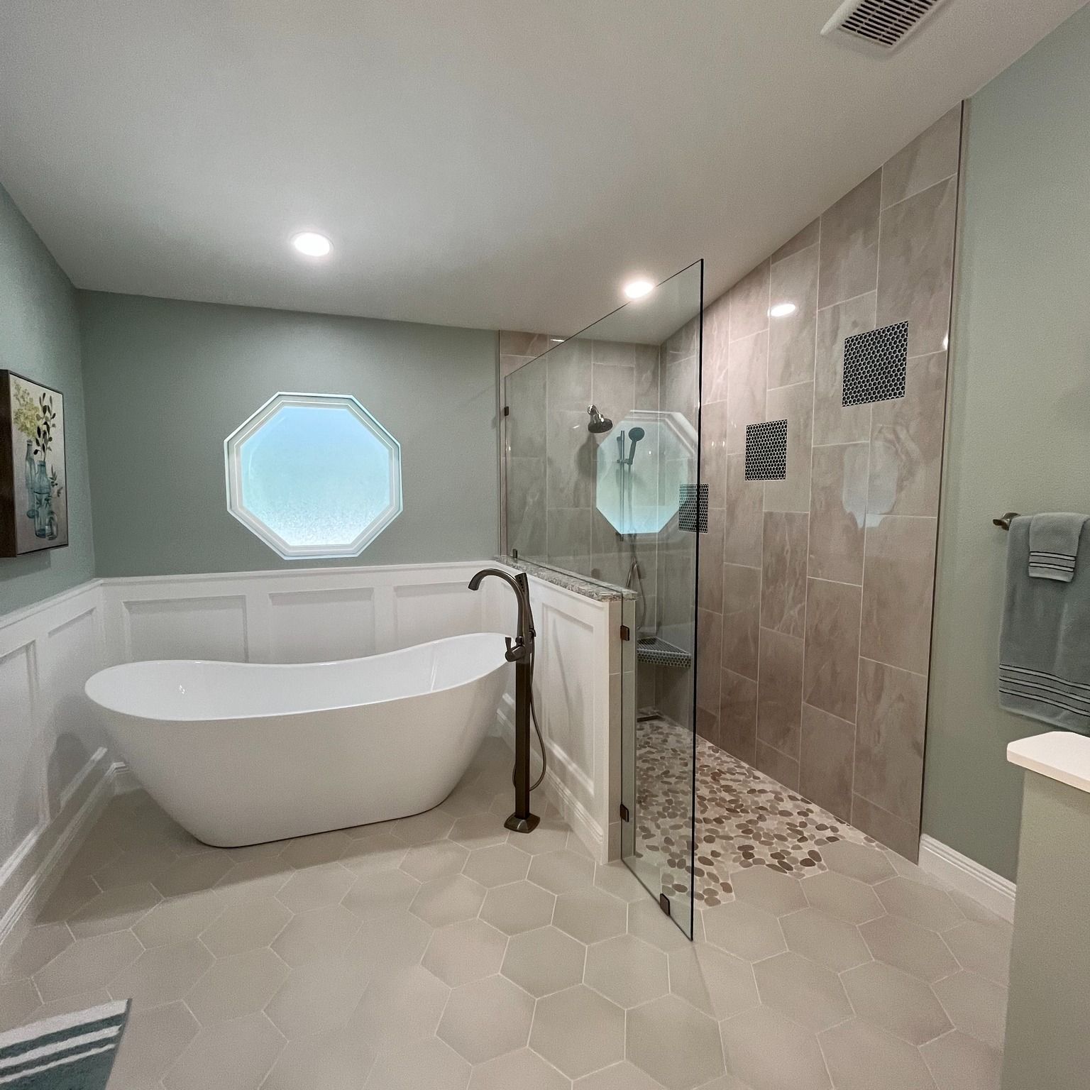 A bathroom with a tub , shower , and window.