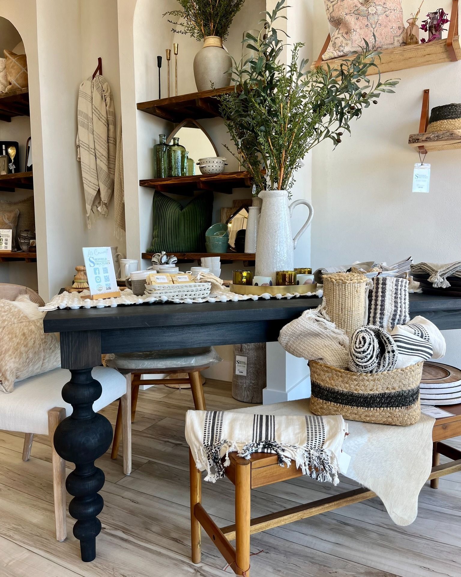 A room with a table and chairs and a vase of flowers on it.