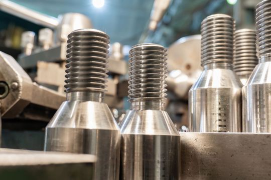 A bunch of metal screws are sitting on top of each other on a machine.