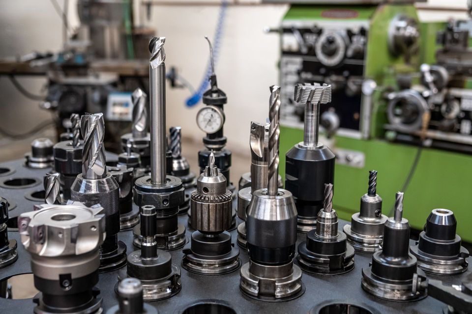 A bunch of metal tools are sitting on a table in a factory.