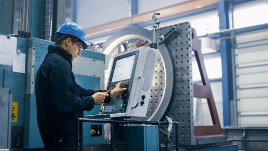 A man is working on a machine in a factory.