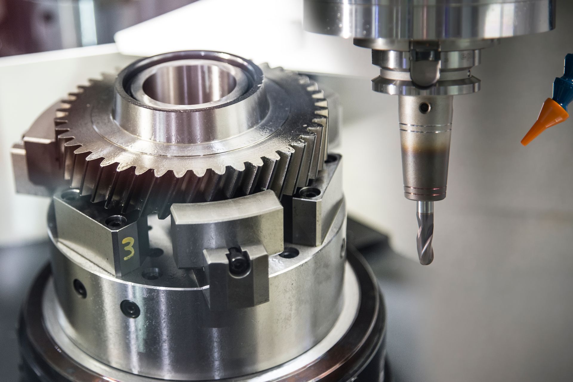 A machine is cutting a gear in a factory.