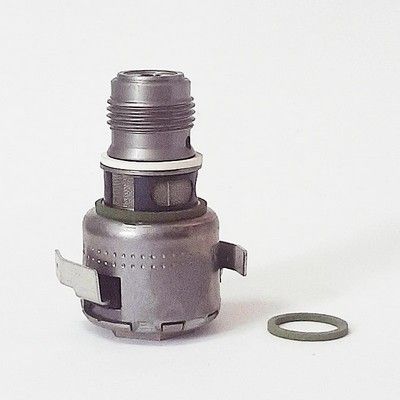 Pieza metálica de automóvil con junta tórica, posiblemente una válvula o un sensor, sobre un fondo blanco.