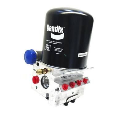 Unidad secadora de aire Bendix, filtro cilíndrico negro sobre una base de metal plateado, con puertos con tapas rojas y azules.