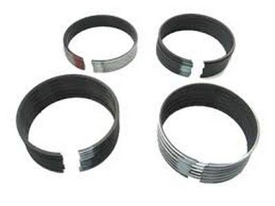 Cuatro anillos de pistón de motor con extremos partidos.