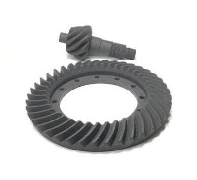 Juego de engranajes de anillo y piñón en metal gris sobre una superficie blanca.