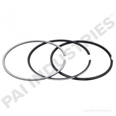 Tres anillos de pistón de metal en diferentes tonos de gris y negro con extremos abiertos.