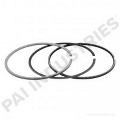 Tres anillos de pistón metálicos, circulares con huecos, dispuestos sobre un fondo blanco.