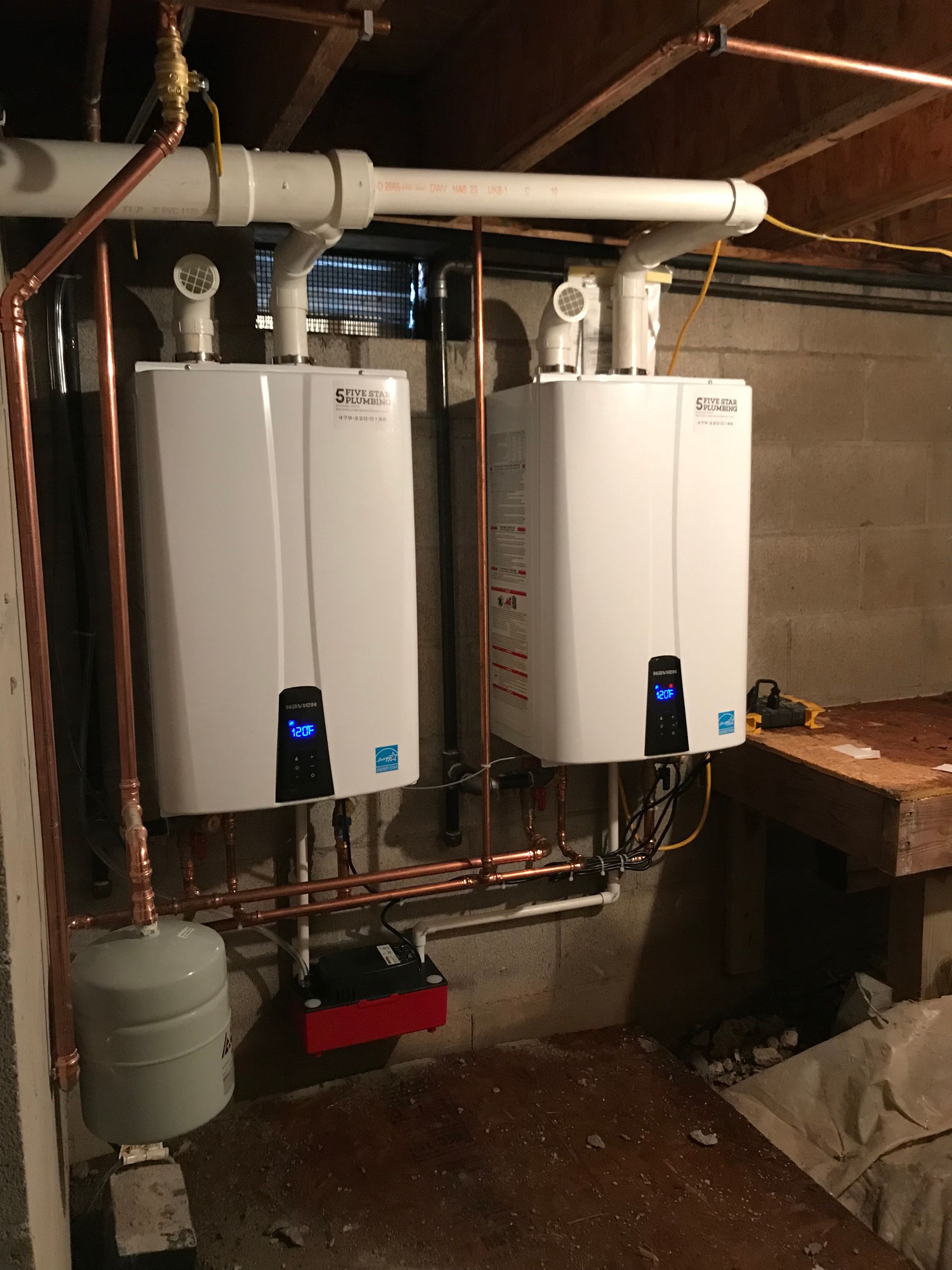 Two water heaters in a basement with copper pipes