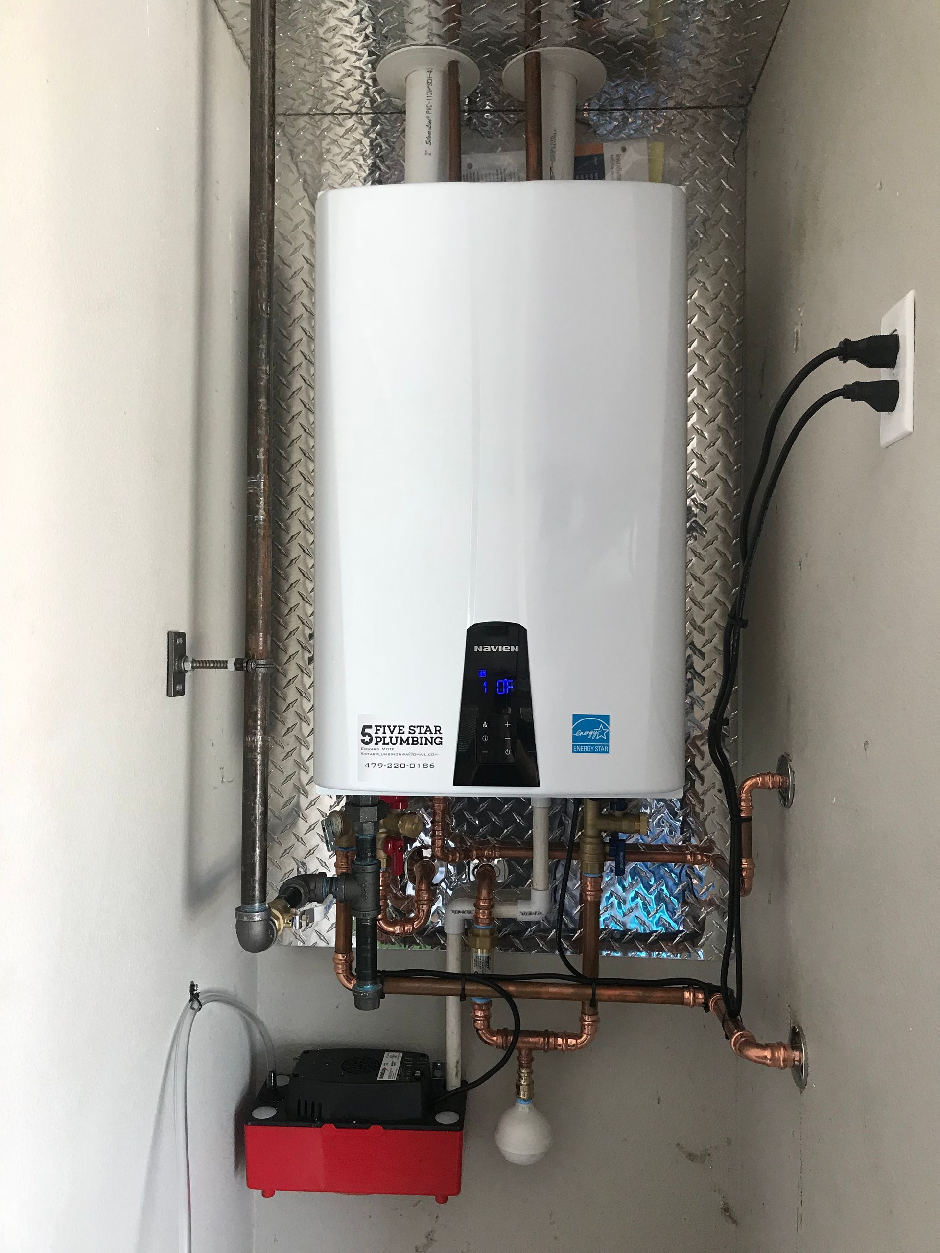 A white water heater is mounted to the wall in a room.