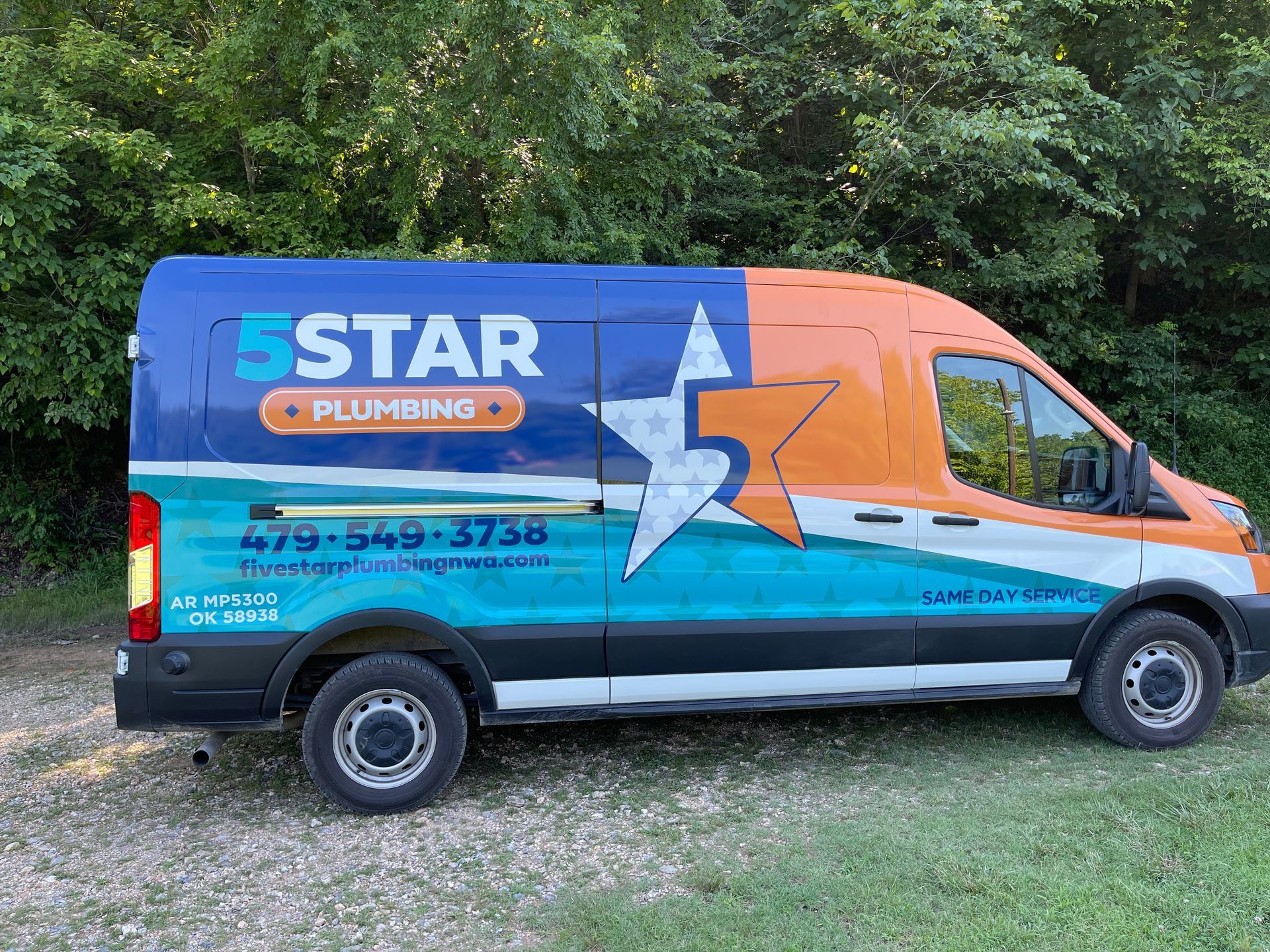 A star plumbing van is parked in the grass