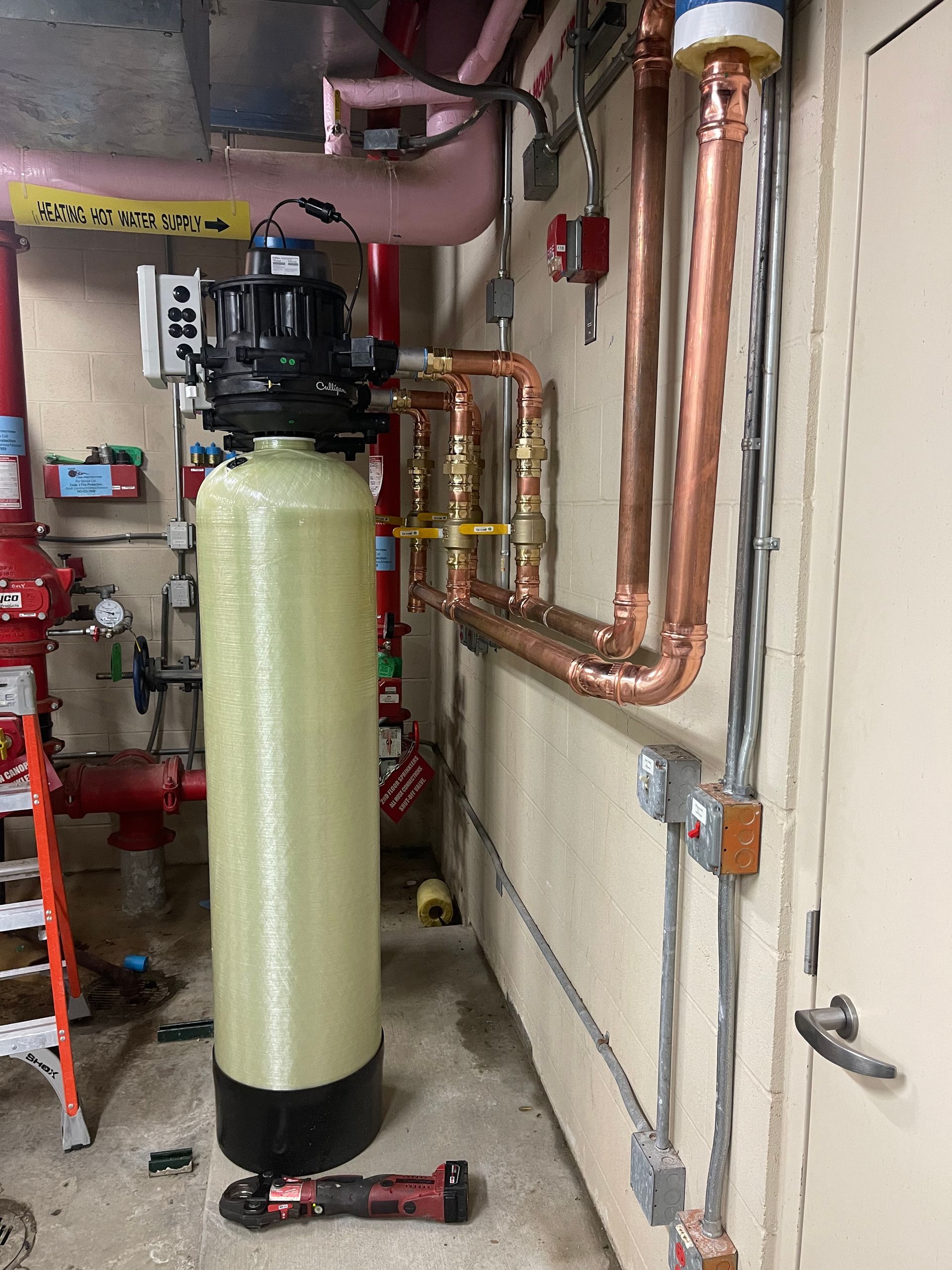 A room with copper pipes and a water filter