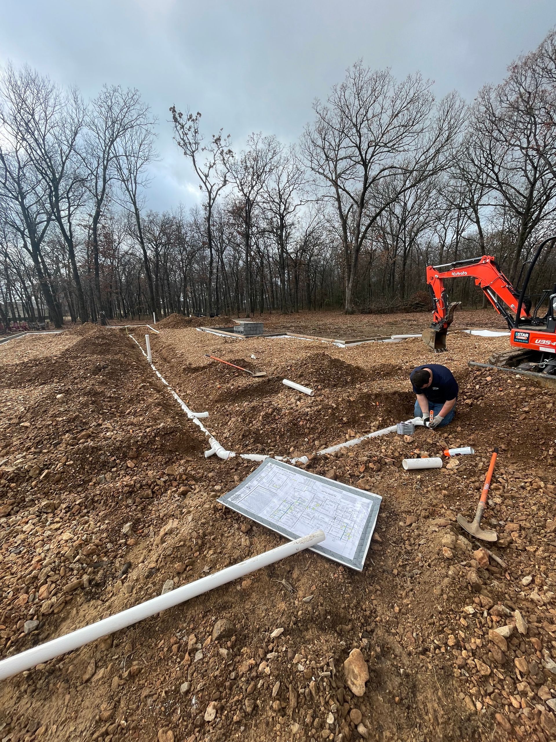 A man is working in the dirt on a construction site.