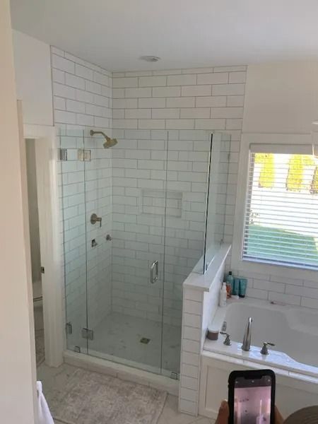 Bathroom with glass walk-in shower, white subway tile, vanity sink, and window blinds