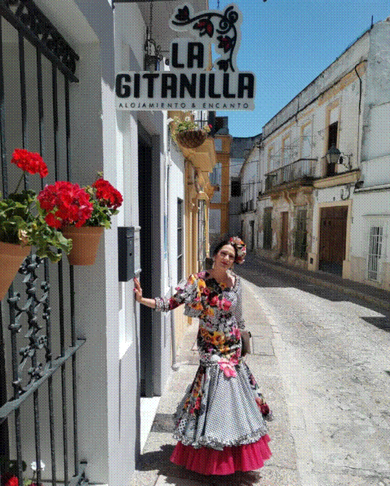 Mujer con vestido floral junto al cartel de 
