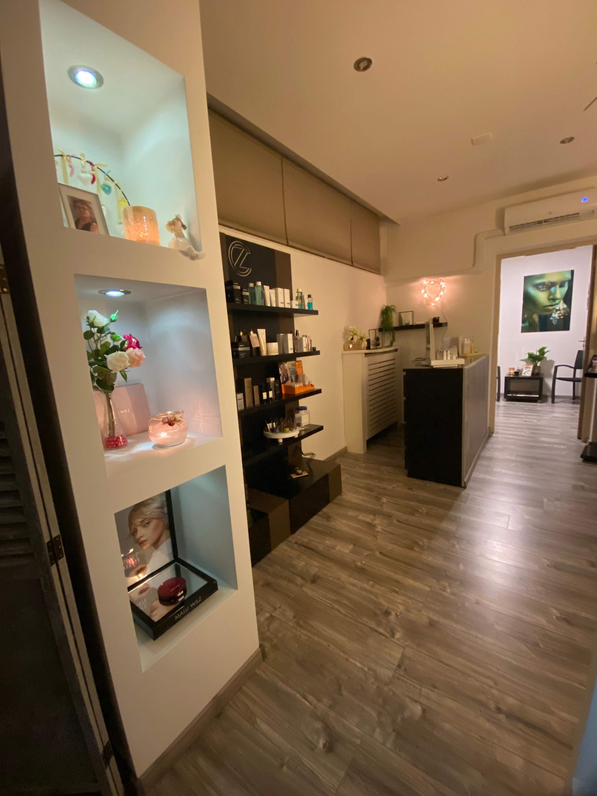 Interieur van een spa met productpresentatieplanken en decoratieve wandnissen.