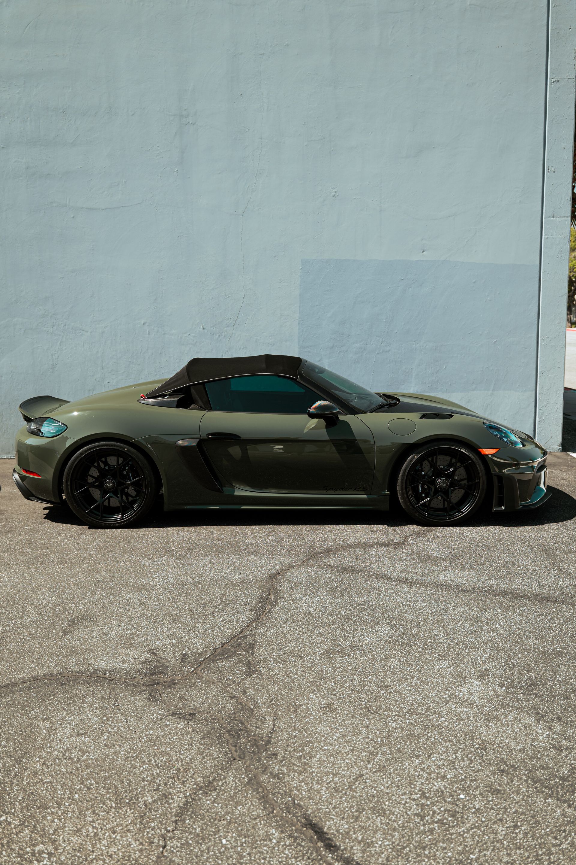 Brown sports car parked outside a Detail Union storefront with awnings