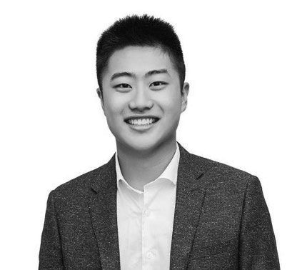 Un homme en costume et chemise blanche sourit sur une photo en noir et blanc. client chez push push propreté