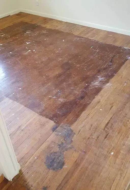 A room with a wooden floor and a white wall.