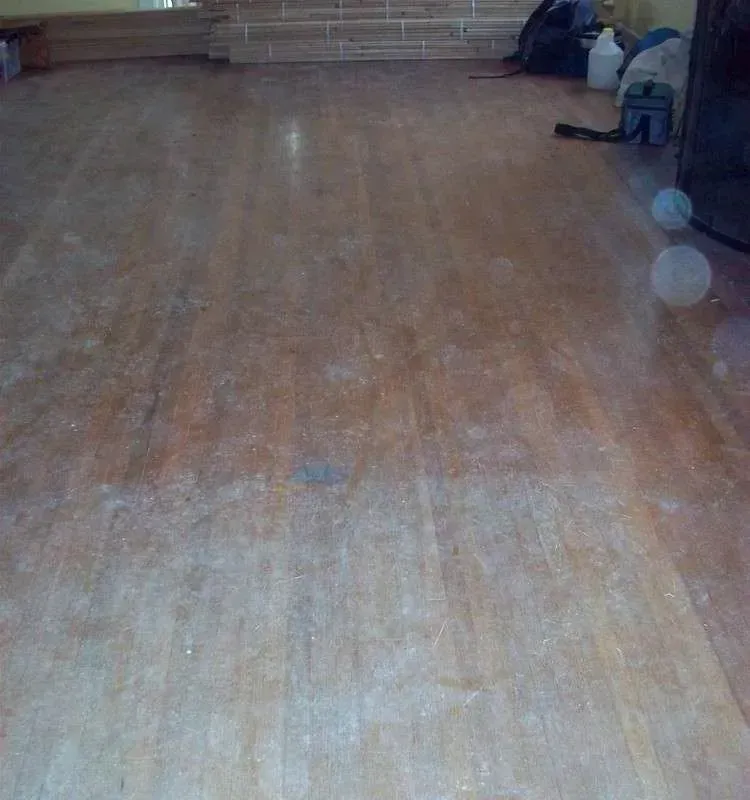 A wooden floor in a room with a vacuum cleaner on it.