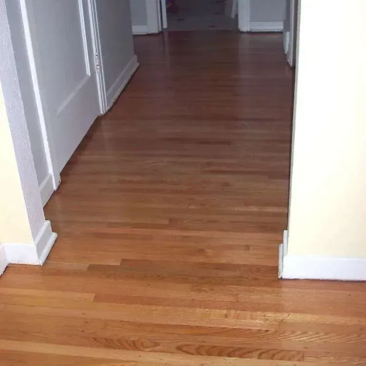 A hallway with hardwood floors and white trim