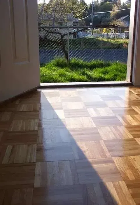 A room with a wooden floor and a door that is open.