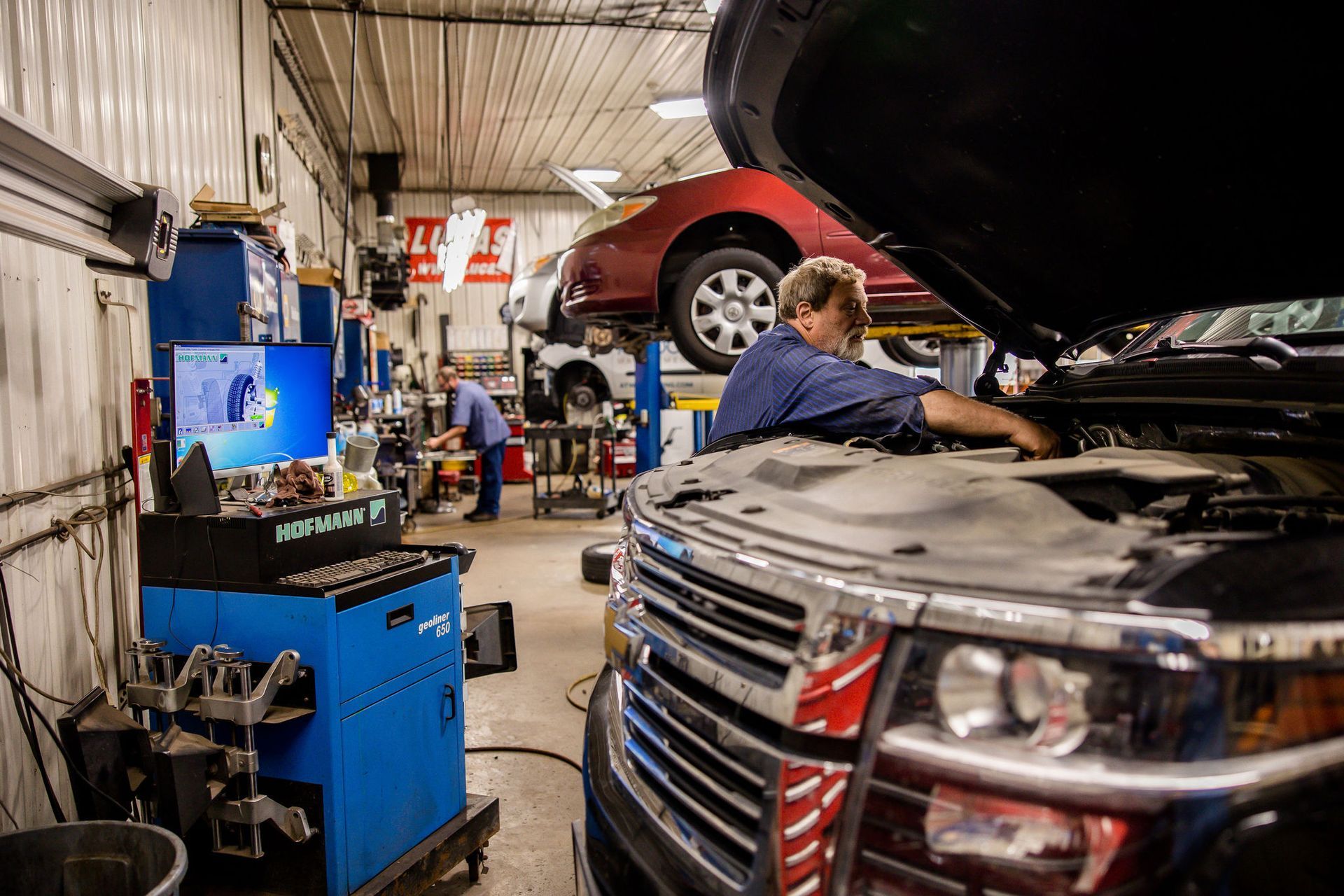 Auto repair shop with two mechanics working on vehicles.
