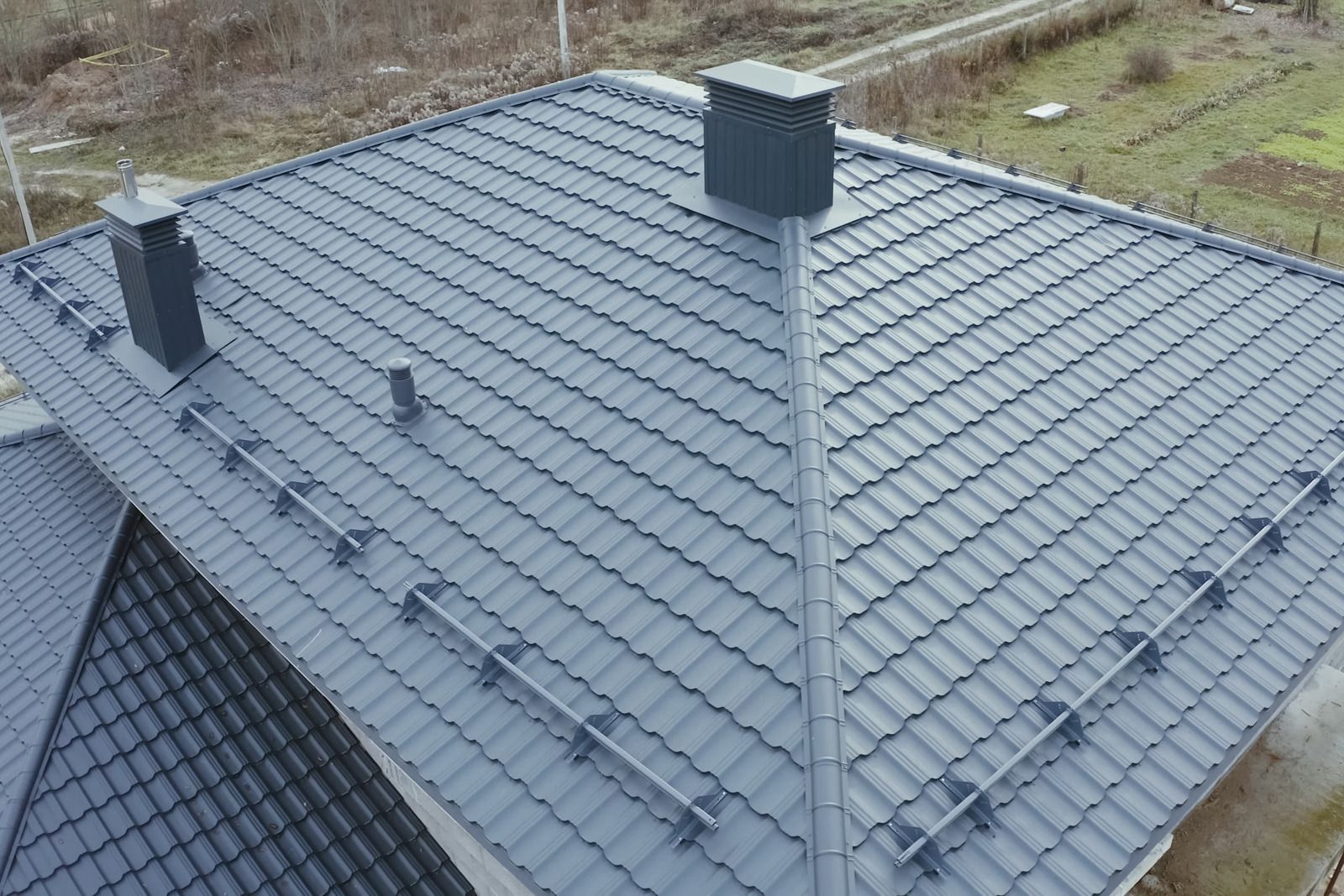 Gray tiled roof with two chimneys, viewed from above