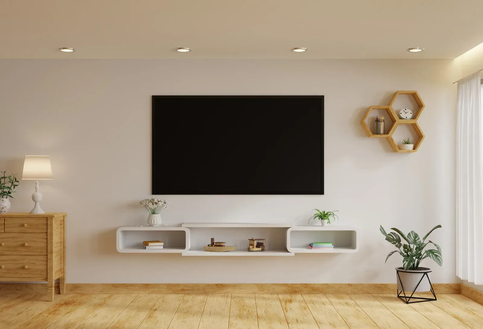 Living room with mounted TV, floating shelf, wooden floor, and decorative plants.