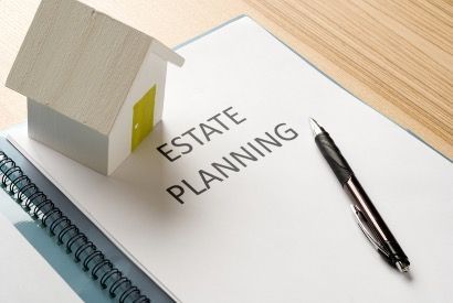 Estate planning document with a house model and pen on a desk