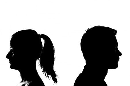 A man and a woman standing back to back.