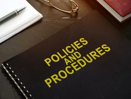 a spiral notebook that says 'policies and procedures' on the front