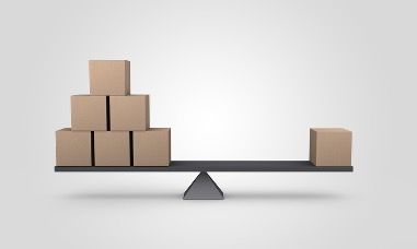 Balanced stack of cardboard boxes on a seesaw, with one box on the other end.