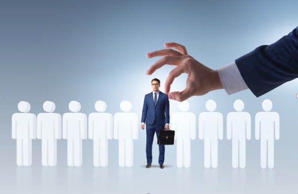 A hand is picking up a man from a line of people.
