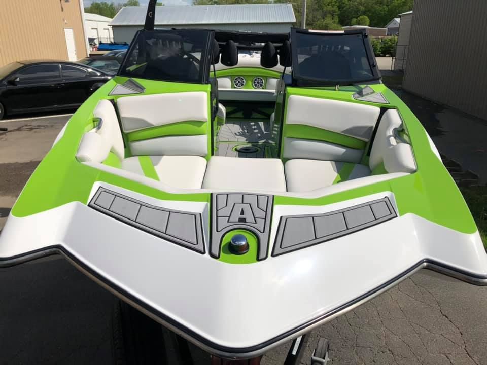 Green and white wake boat with black accents and seats.