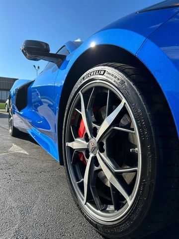 A blue sports car is parked on the side of the road.
