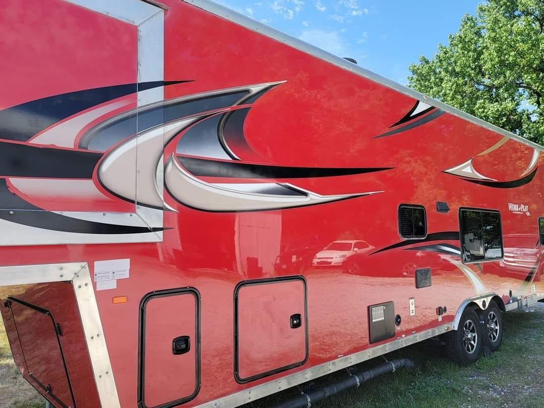 Red and black trailer with graphics, parked outdoors.