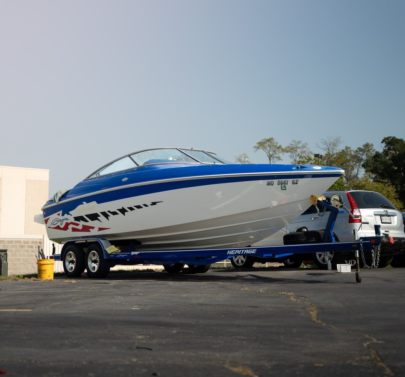 A red and white boat is parked in a garage.