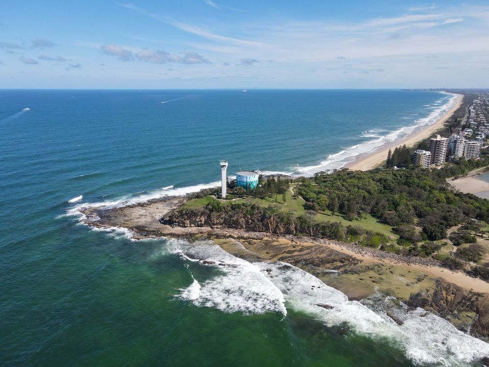 Aerial View Of A Beach With A White Lighthouse — Superstretch300 Limousines In Mooloolaba, QLD