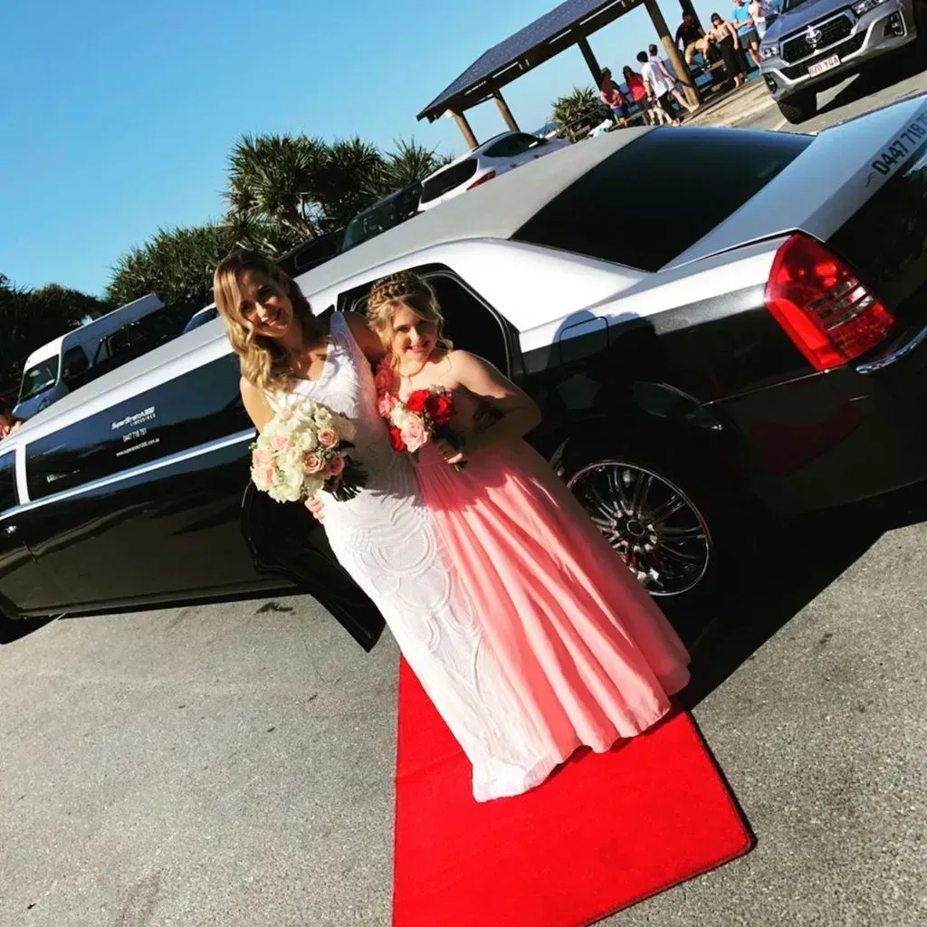 A Bride and Her Flower Girl Are Standing on a Red Carpet — Superstretch300 Limousines in Sunshine Coast, QLD