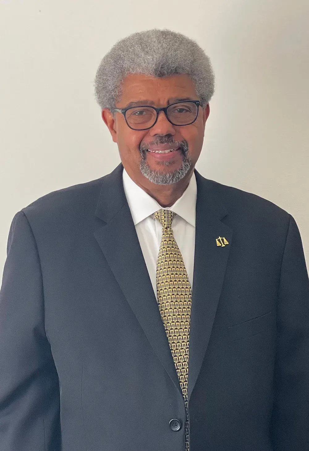 A man in a suit and tie is smiling for the camera