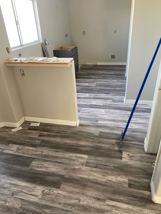 A mop is sitting on a wooden floor in a room.