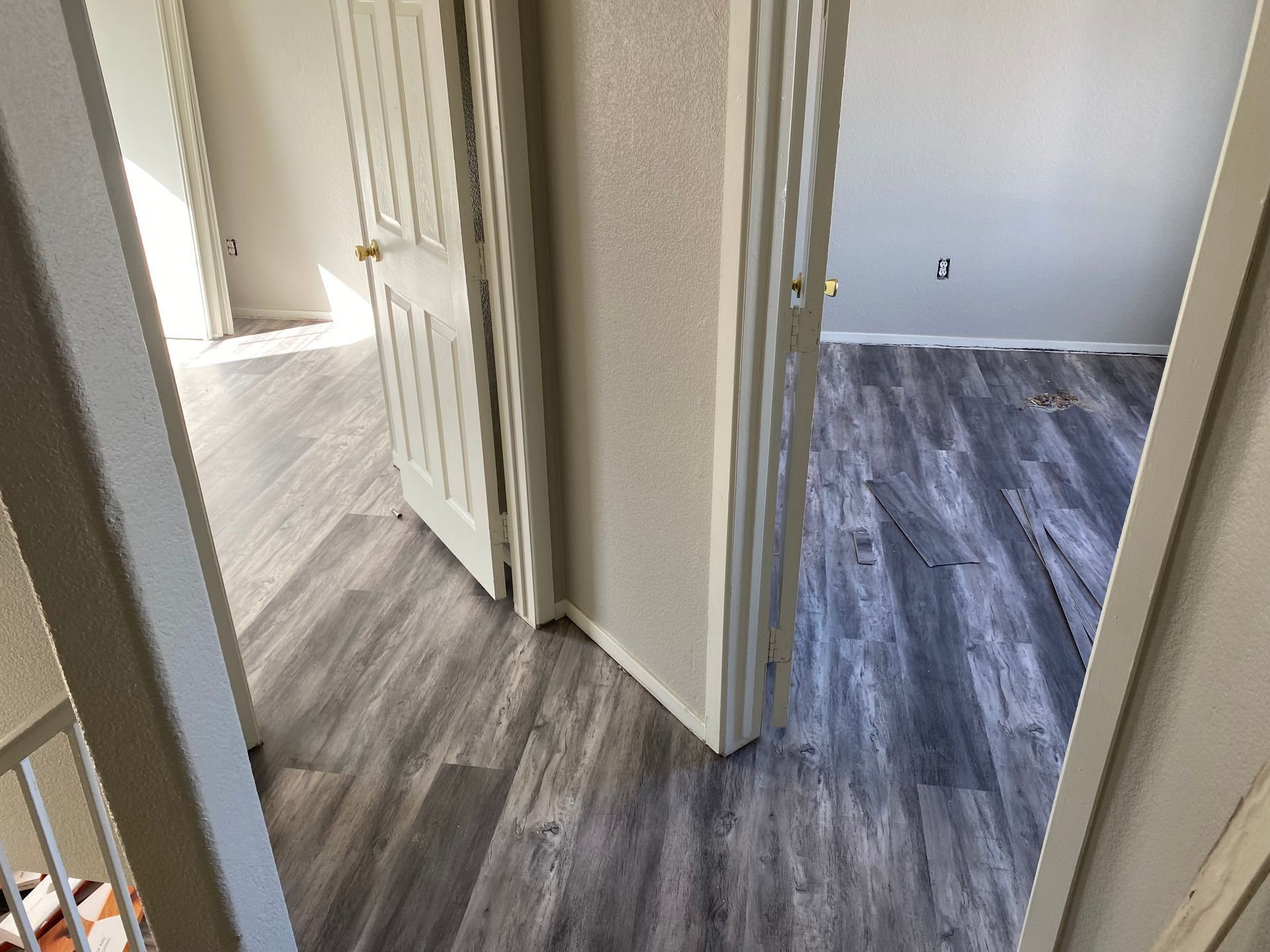 A hallway in a house with hardwood floors and a closet.