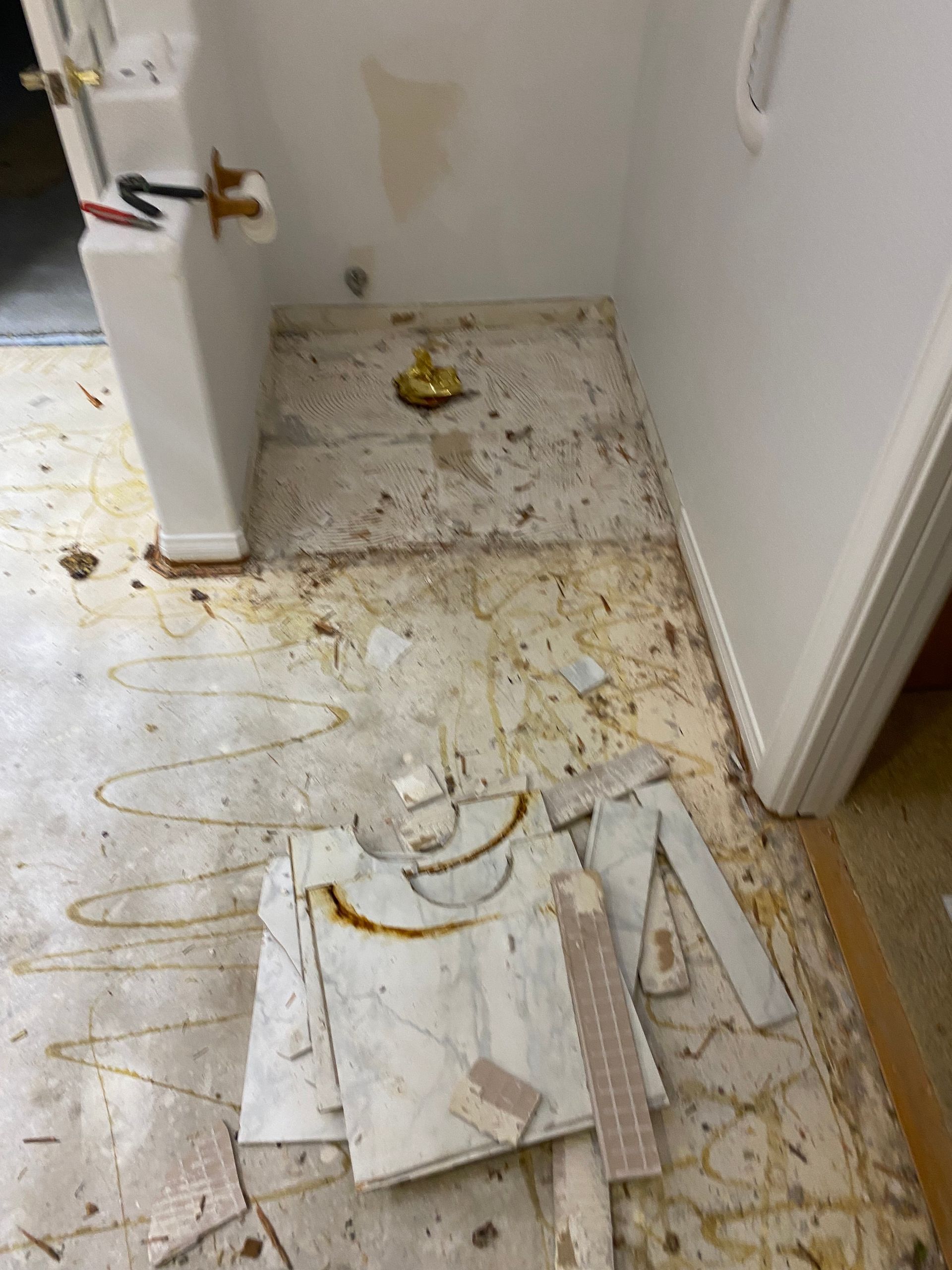 A bathroom with a broken tile on the floor