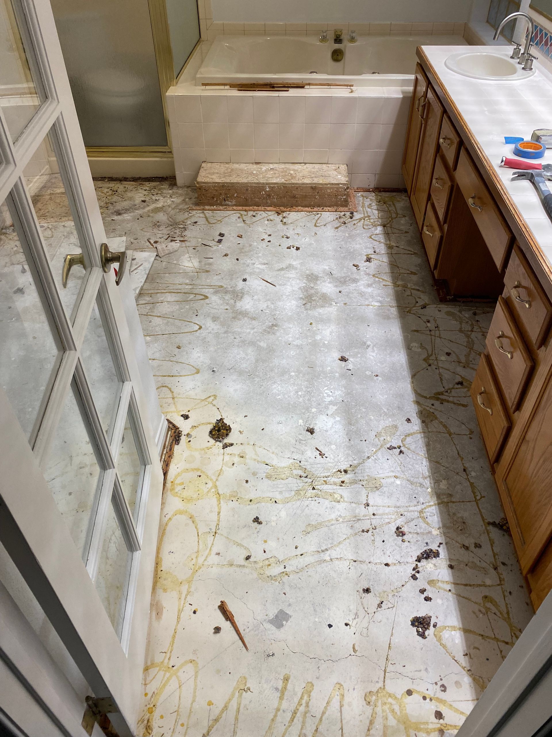 A bathroom with a dirty floor and a bathtub.