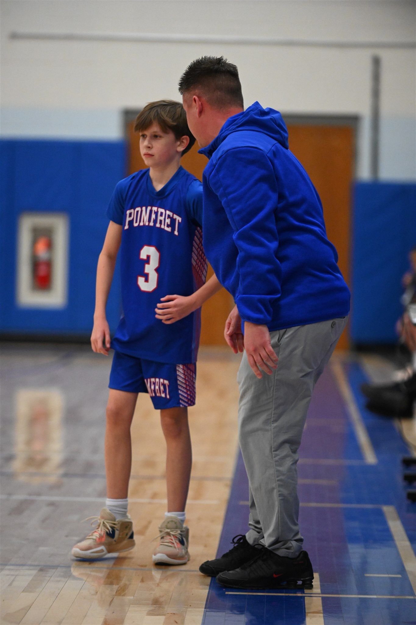 member of the 2023-24 boys basketball teamtalking with the coach